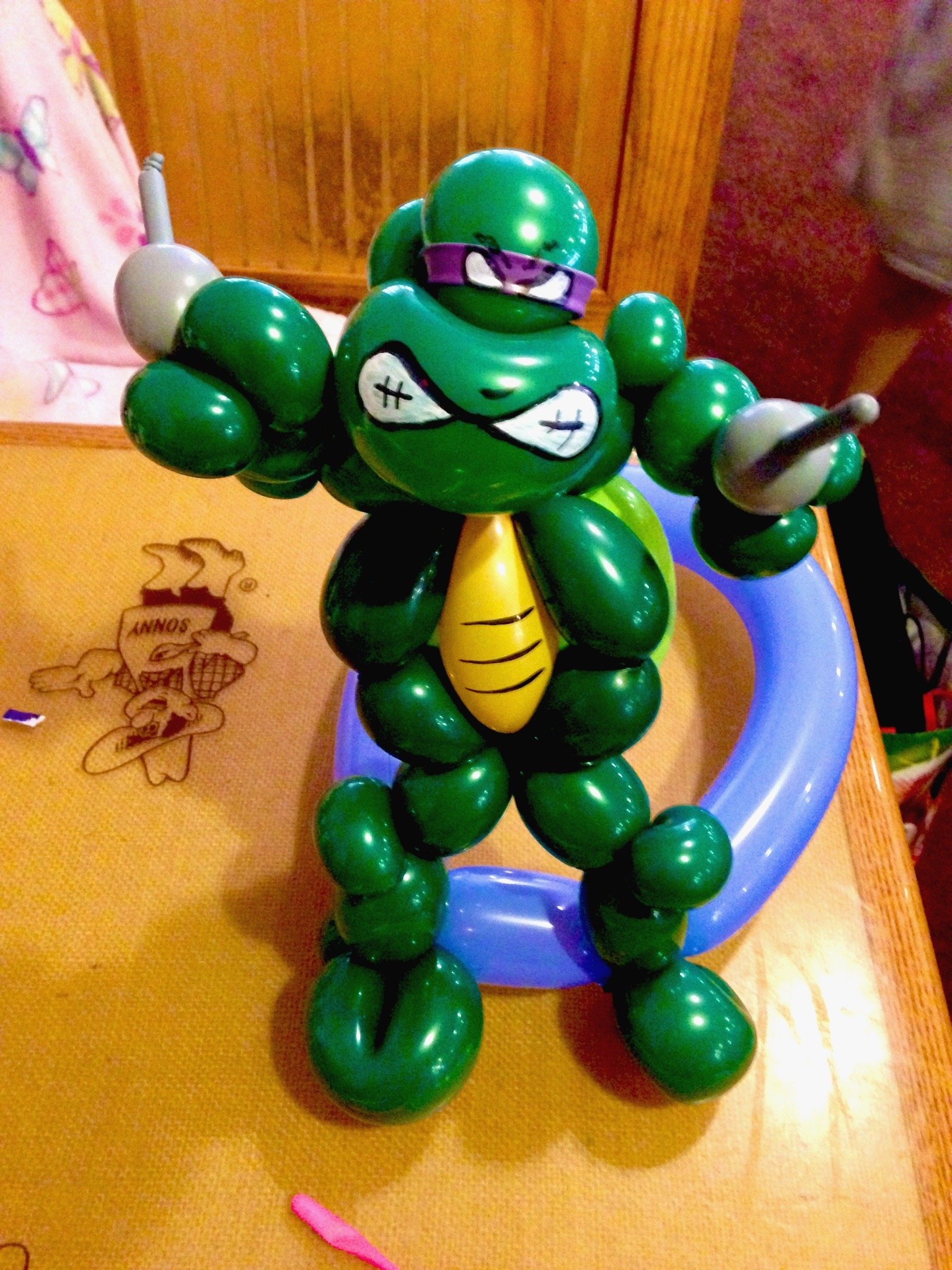 Balloon artist creating sculptures for kids at restaurant table