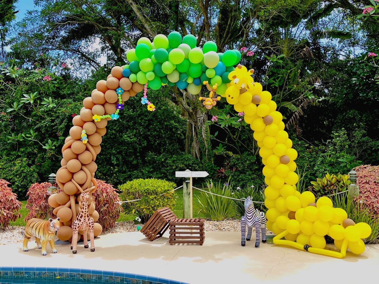 Organic balloon arch with animal figures at outdoor event
