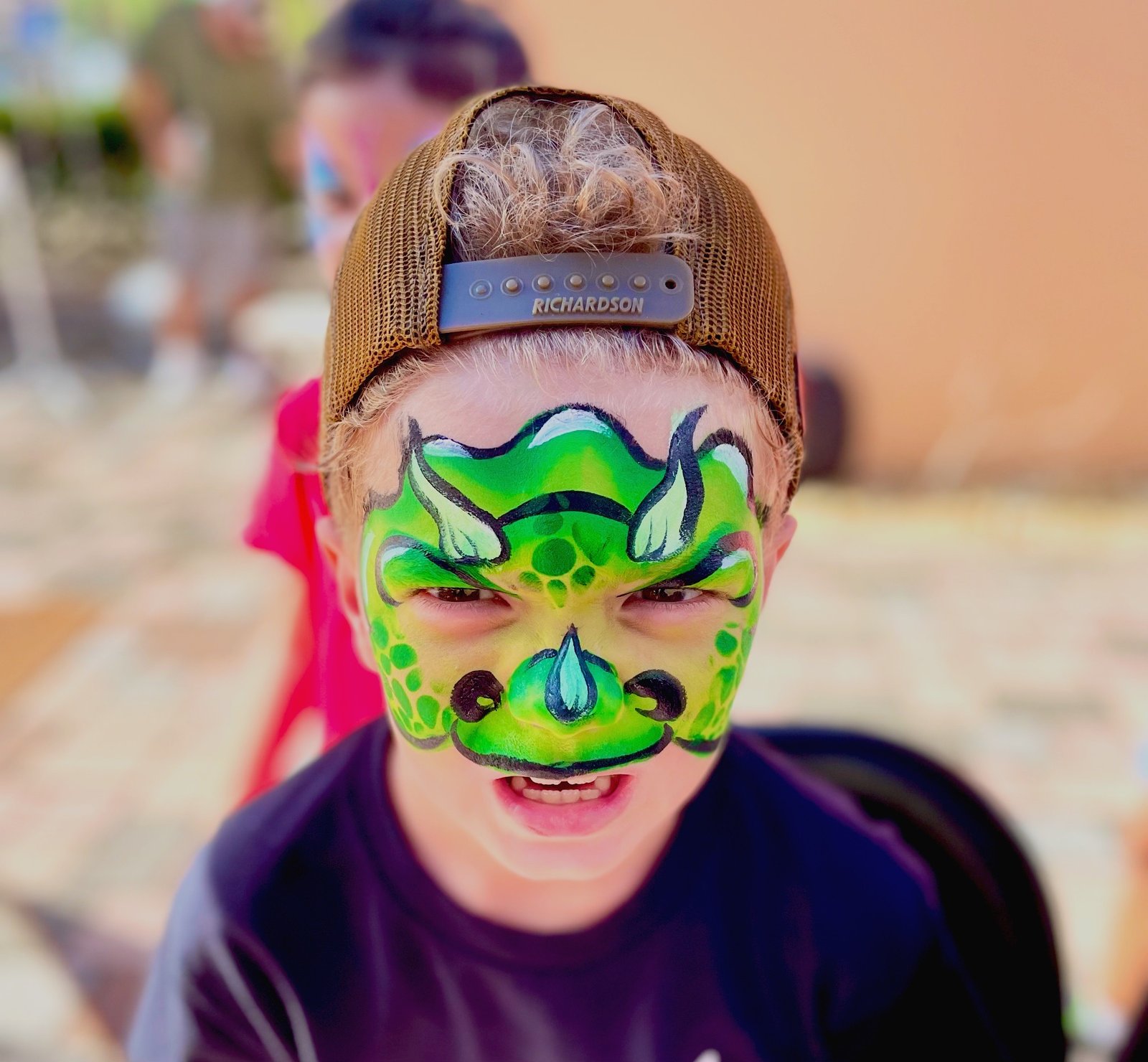 Face painter creating designs for children at an event